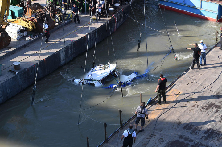Petugas penyelamat dan anggota kru dibantu derek apung raksasa di atas kapal Clark Adam, berusaha mengangkat perahu wisata 'Mermaid' yang tenggelam di Sungai Danube, Budapest, Selasa, 11 Juni 2019.