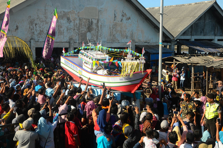 Warga mengangkat miniatur kapal yang berisi sesaji kepala kerbau, ingkung (ayam utuh), jajanan pasar, serta kupat dan lepat, sebelum dilarung di Pantai Kartini, Jepara, Rabu, 12 Juni 2019.