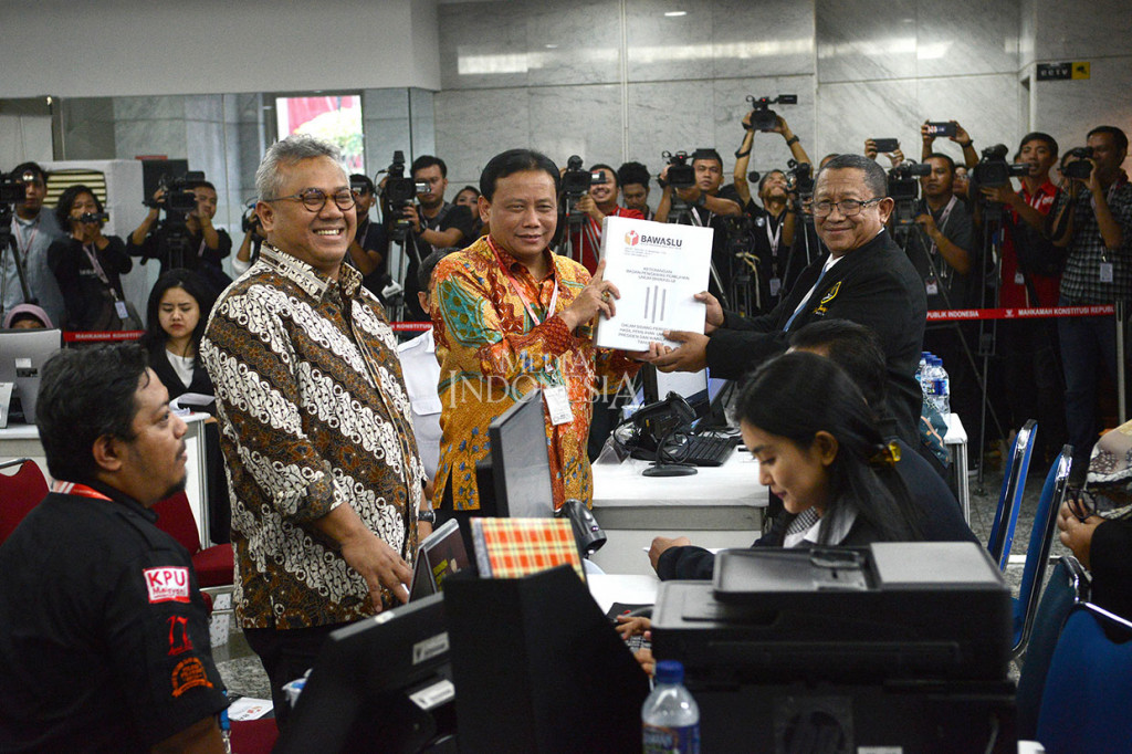 Ketua Badan Pengawas Pemilu (Bawaslu) Abhan (tengah) dan Ketua Komisi Pemilihan Umum (KPU) Arief Budiman menyerah kanberkas jawaban, keterangan, dan alat bukti terkait gugatan perselisihan hasil pemilihan umum (PHPU) ke Mahkamah Konstitusi, di Jakarta, Rabu, 12 Juni 2019.