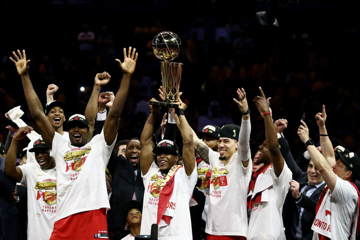 Para pemain Toronto Raptors melakukan selebrasi sambil mengangat trofi usai memastikan diri menjadi juara NBA musim 2018/2019, Jumat, 14 Juni 2019.