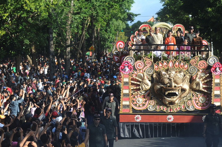 Saat berada di atas kendaraan tersebut, Jokowi, Iriana, dan sang cucu Jan Ethes tak henti melambaikan tangan kepada masyarakat Bali yang berdiri di sisi kanan-kiri Jalan Raya Puputan, Renon, sebagai jalan yang dilintasi pawai tersebut. Warga menyemut dan terlihat begitu antusias menyambut Presiden yang berdiri di atas kendaraan hias. Antara Foto/Fikri Yusuf
