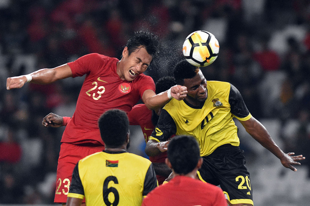 Pesepak bola timnas Indonesia Hansamu Yama (kiri) berebut bola di udara dengan pesepak bola timnas Vanuatu Selwyn Vatu. Antara Foto/M Risyal Hidayat
