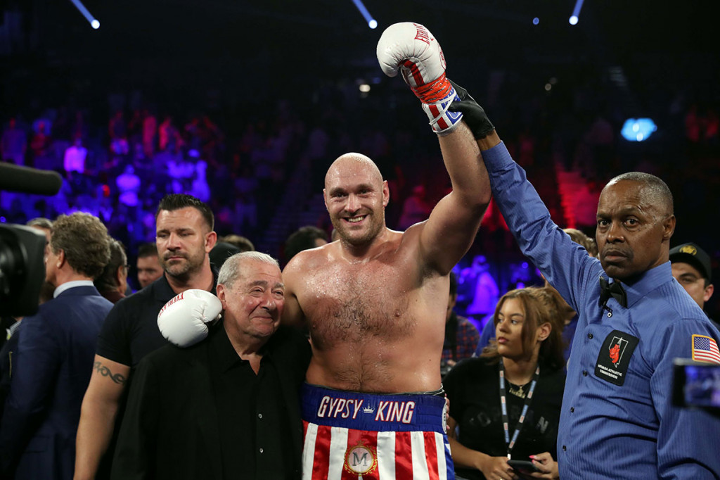 Tyson Fury berpose bersama promotor tinju Bob Arum (kiri) dan wasit Kenny Bayless usai mengalahkan Tom Schwarz dalam pertarungan tinju kelas berat non gelar di MGM Grand Garden Arena, Las Vegas, Minggu, 16 Juni 2019 WIB. Fury menang dengan TKO pada ronde kedua.