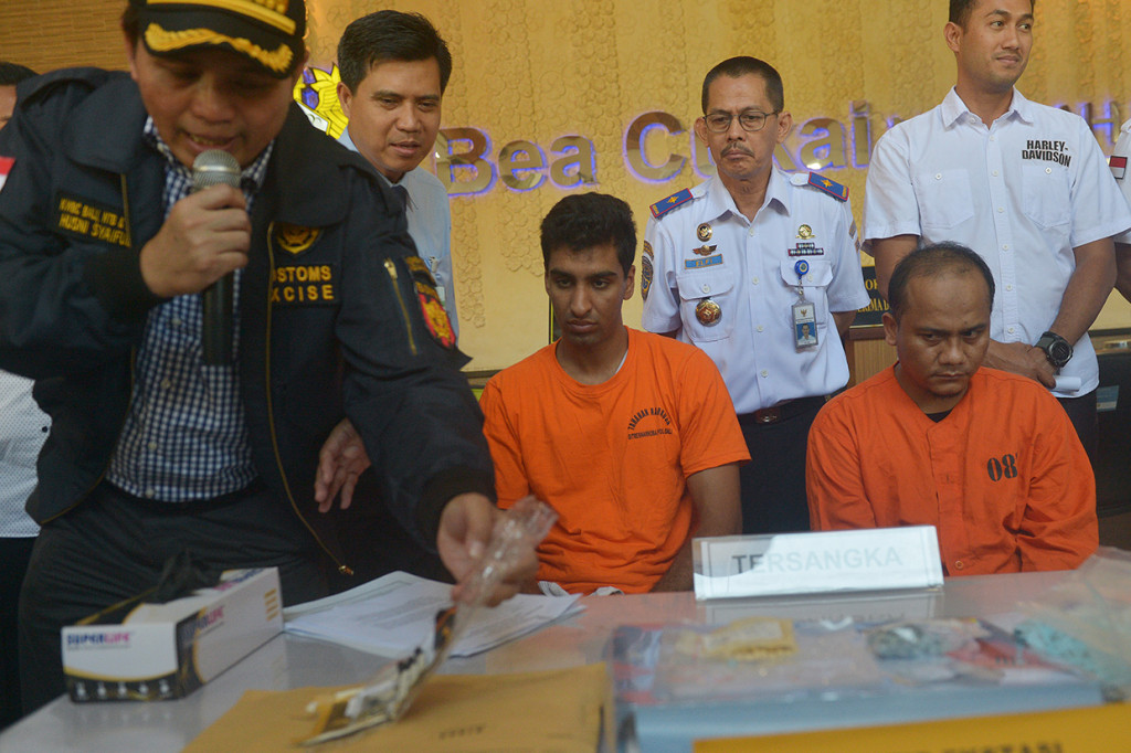 Petugas Bea Cukai memperlihatkan barang bukti narkoba beserta tersangka warga negara Amerika Serikat, JAP (kedua kiri) dan tersangka penerima paket narkoba AW (kanan) dalam konferensi pers di Kantor Bea Cukai Ngurah Rai, Denpasar.