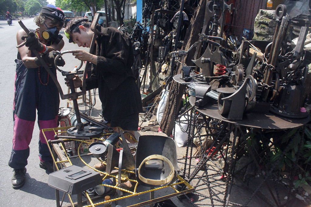 Seniman patung asal Malang Sumarsono (kiri) berkolaborasi dengan pematung asal Inggris, Michelle Laing tengah membuat patung dari besi bekas di Malang, Jawa Timur, Rabu, 19 Juni 2019. 