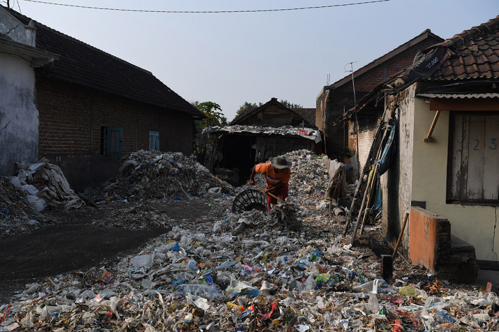Sejumlah anak berlarian di tumpukan sampah plastik impor di Desa Bangun di Mojokerto, Jawa Timur.