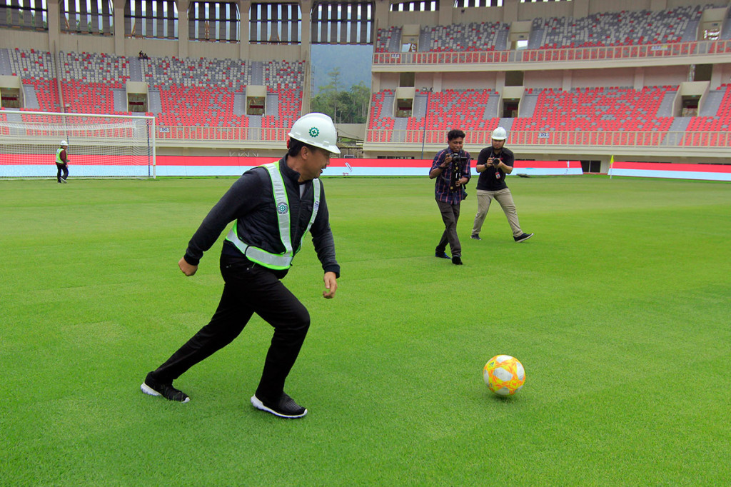 Menpora Imam Nahrawi bermain bola saat menjajal rumput lapangan Stadion Papua Bangkit, Kampung Harapan, Jayapura, Papua, Jumat, 21 Juni 2019. 