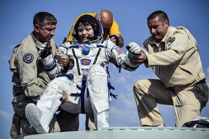 Petugas membantu astronot NASA Anne McClain untuk keluar dari kapsul Soyuz MS-11 tak lama setelah mendarat di tenggara kota Dzhezkazgan di padang rumput Kazakhstan. Afp Photo/Alexander Nemenov