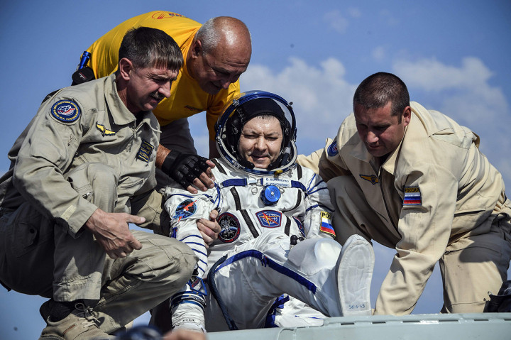 Petugas membantu Kosmonot Rusia Oleg Kononenko untuk keluar dari kapsul Soyuz MS-11 tak lama setelah mendarat di tenggara kota Dzhezkazgan di padang rumput Kazakhstan. Afp Photo/Alexander Nemenov