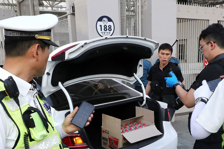 Polisi menyelidiki mobil yang ringsek yang tampaknya sengaja digunakan untuk menabrak gerbang utama Kedutaan Besar AS di Seoul, Korsel, Selasa, 25 Juni 2019. 