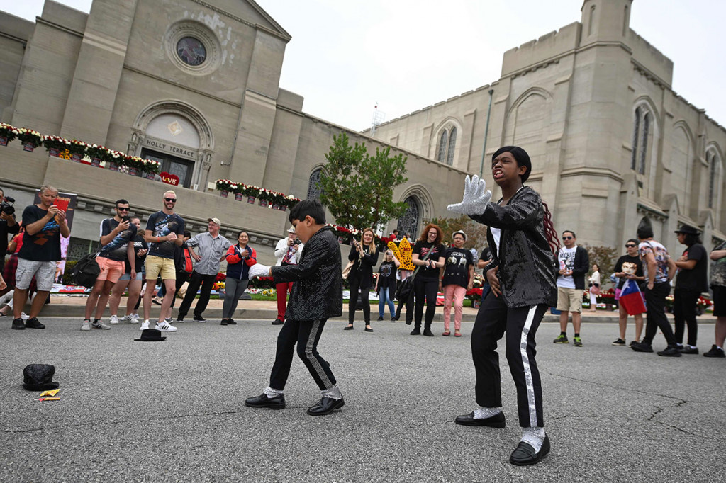 Penggemar cilik Tanisha Woods (kanan) dan Dominic Lendo menari menirukan gaya idolanya Michael Jackson di luar peristirahatan terakhir Raja Pop tersebut di Forest Lawn Cemetery, Glenade, California, Selasa, 25 Juni 2019 waktu setempat.
