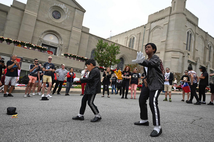 Penggemar cilik Tanisha Woods (kanan) dan Dominic Lendo menari menirukan gaya idolanya Michael Jackson di luar peristirahatan terakhir Raja Pop tersebut di Forest Lawn Cemetery, Glenade, California, Selasa, 25 Juni 2019 waktu setempat.
