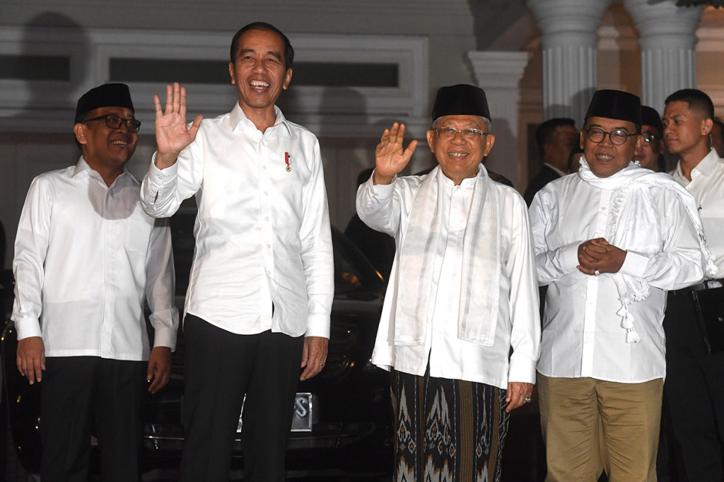 Didampingi Menteri Sekretaris Negara Pratikno, Jokowi langsung disambut Kiai Ma'ruf yang mengenakan baju koko warna putih, peci hitam, dan bawahan sarung. Jokowi dan Ma'ruf juga menyapa awak media yang telah menunggu sejak siang dari teras. Antara Foto/Akbar Nugroho Gumay