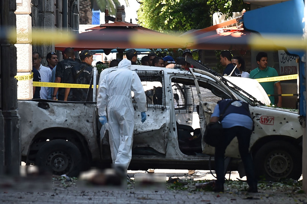 Ahli forensik melakukan pemeriksaan terhadap sebuah kendaraan yang hancur akibat ledakan bom bunuh diri di sebuah jalan utama Ibu kota Tunisia, Tunis, Kamis, 27 Juni 2019 waktu setempat.