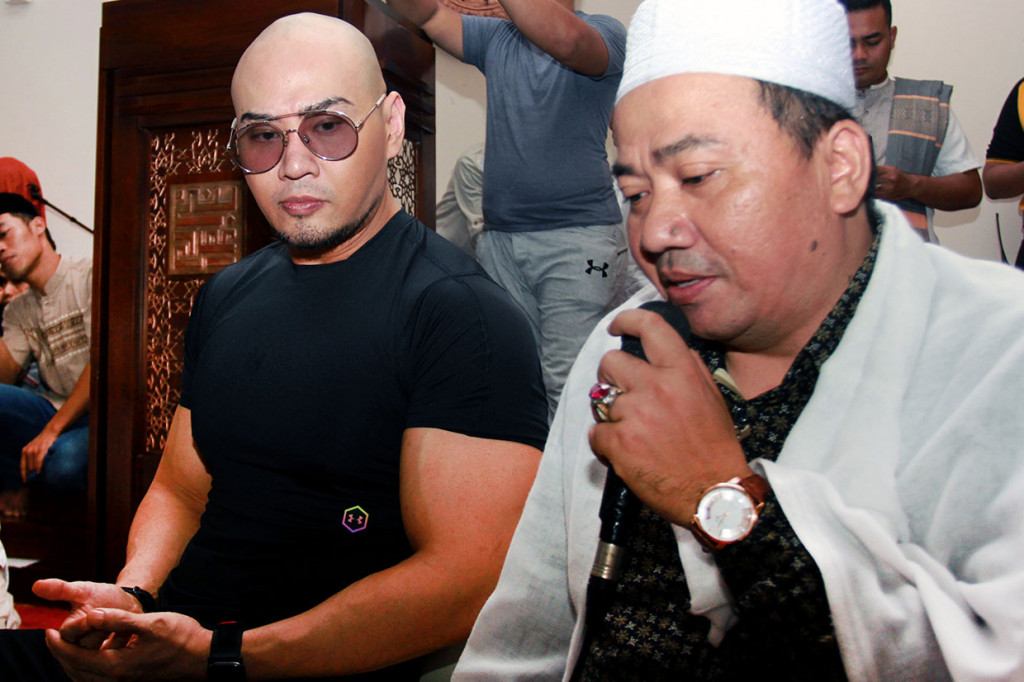 Mantan mentalis Indonesia Deddy Corbuzier (kiri) didampingi Imam Masjid memanjatkan doa usai melaksanakan Salat Jumat di Masjid Bani Umar Pondok Aren, Tangerang Selatan, Banten, Jumat, 28 Juni 2019. 