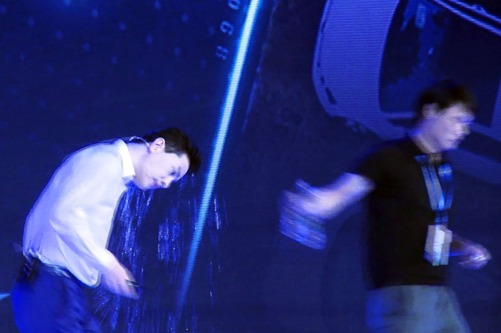 Li hanya bisa berdiri tertegun saat disiram air oleh pria yang tidak dikenal tersebut. 