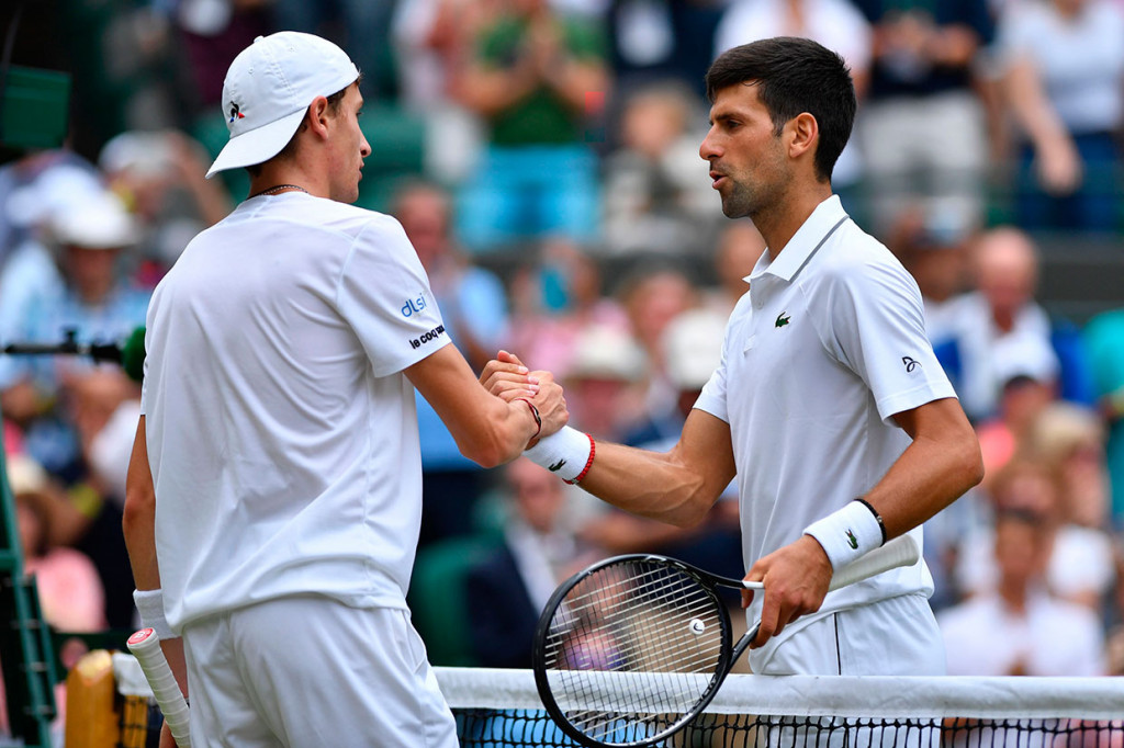 Petenis Serbia Novak Djokovic berjabat tangan dengan lawannya petenis Prancis Ugo Humbert usai melangsungkan laga babak keempat turnamen tenis Wimbledon, Senin, 8 Juli 2019 waktu setempat.