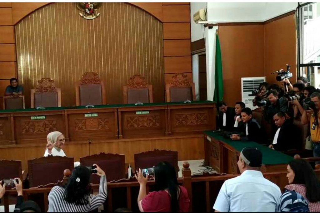 Saat memasuki ruang sidang, Ratna sempat berpose dua jari.
