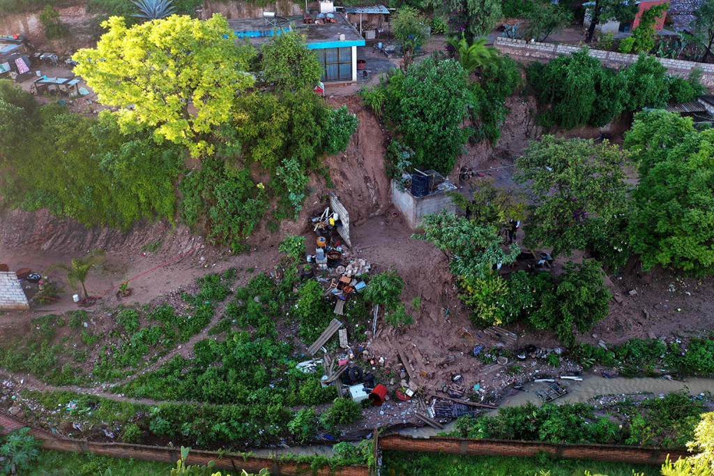 Warga berada di lokasi di mana sebuah rumah tertimpa tanah longsor di Santo Thomas Chautla, pinggiran Puebla, Meksiko, Kamis, 11 Juli 2019 waktu setempat.