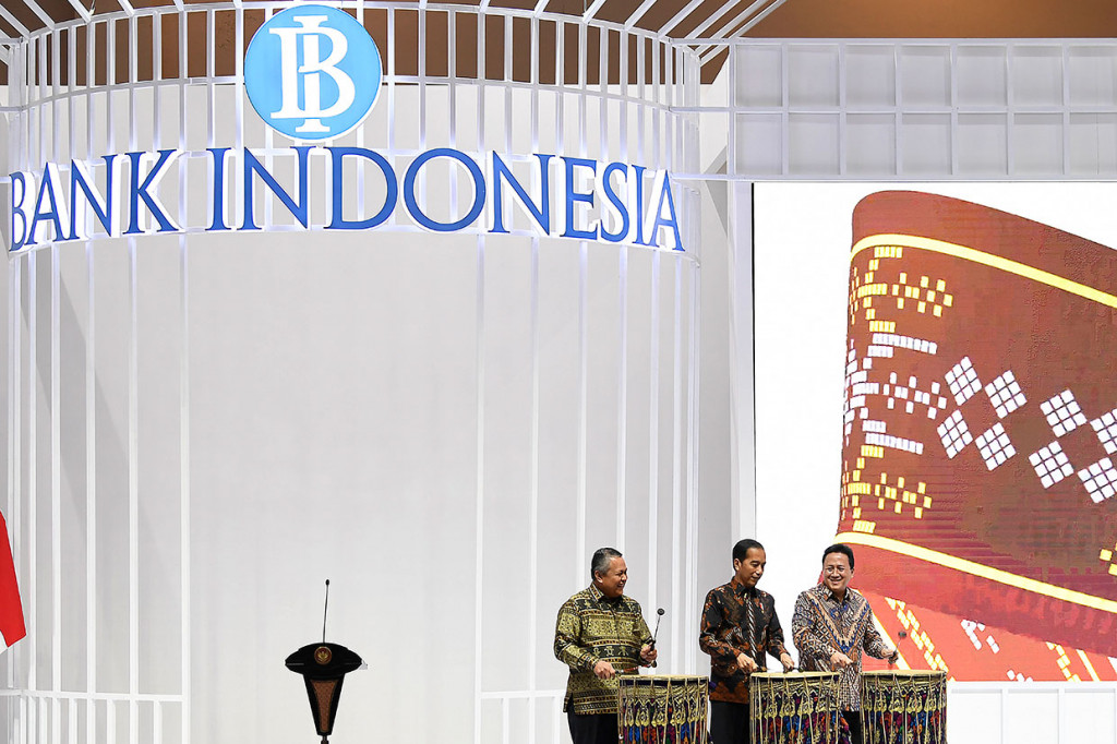 Presiden Joko Widodo (tengah) didampingi Kepala Bekraf Triawan Munaf (kanan) dan Gubernur Bank Indonesia Perry Warjiyo memukul beduk menandai pembukaan Pameran Karya Kreatif Indonesia di JCC Senayan, Jakarta, Jumat, 12 Juli 2019.