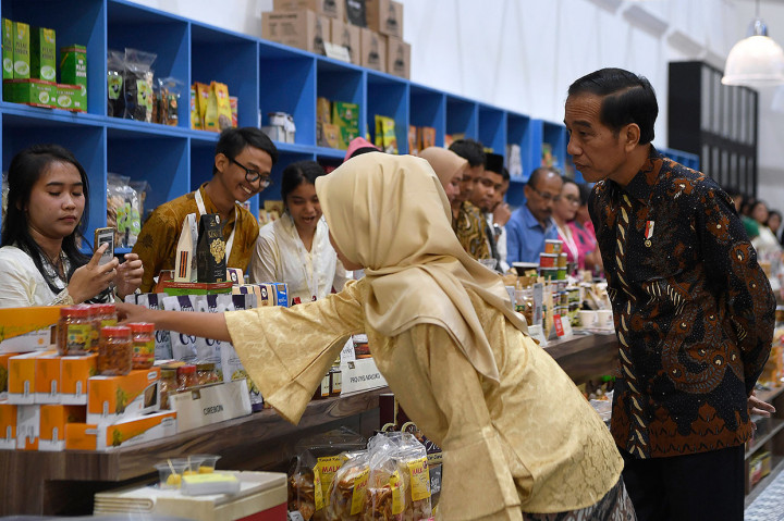 Jokowi dengan seksama mendengarkan penjelasan salah satu pelaku UMKM peserta Pameran Karya Kreatif Indonesia.