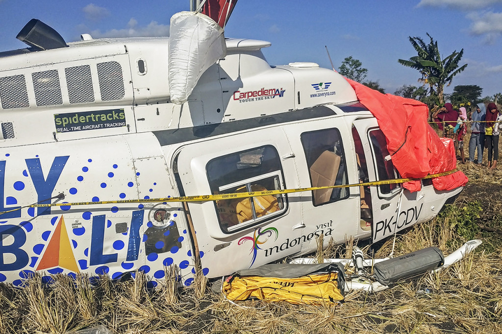 Sejumlah warga berada di dekat pesawat helikopter B206L4 PKCDV milik PT. Carpediem Air rute Labuan Bajo-Lombok yang jatuh di luar pagar Bandara Internasional Lombok di Desa Kawo, Kecamatan Pujut, Praya, Lombok Tengah, NTB.