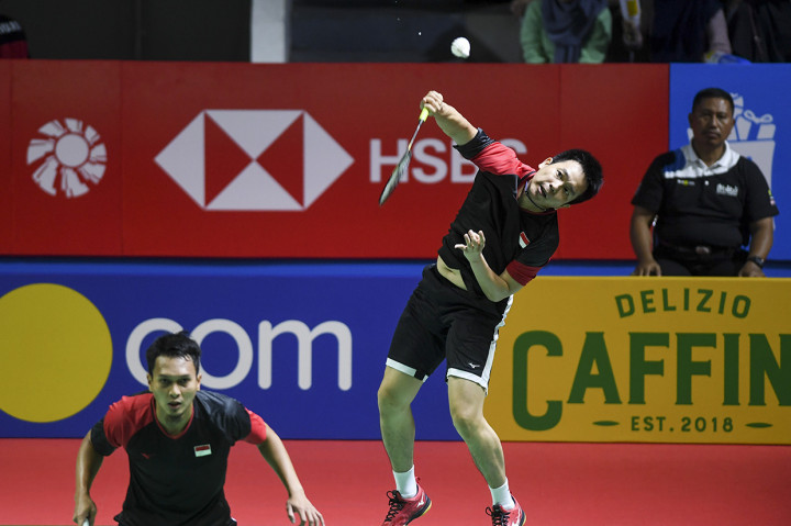 Ganda putra Indonesia Hendra Setiawan (kanan) dan Mohammad Ahsan (kiri) mengembalikan kok ke ganda putra Inggris Marcus Ellis dan Chris Langridge pada babak pertama Blibli Indonesia Open 2019 di Istora Senayan, Jakarta.