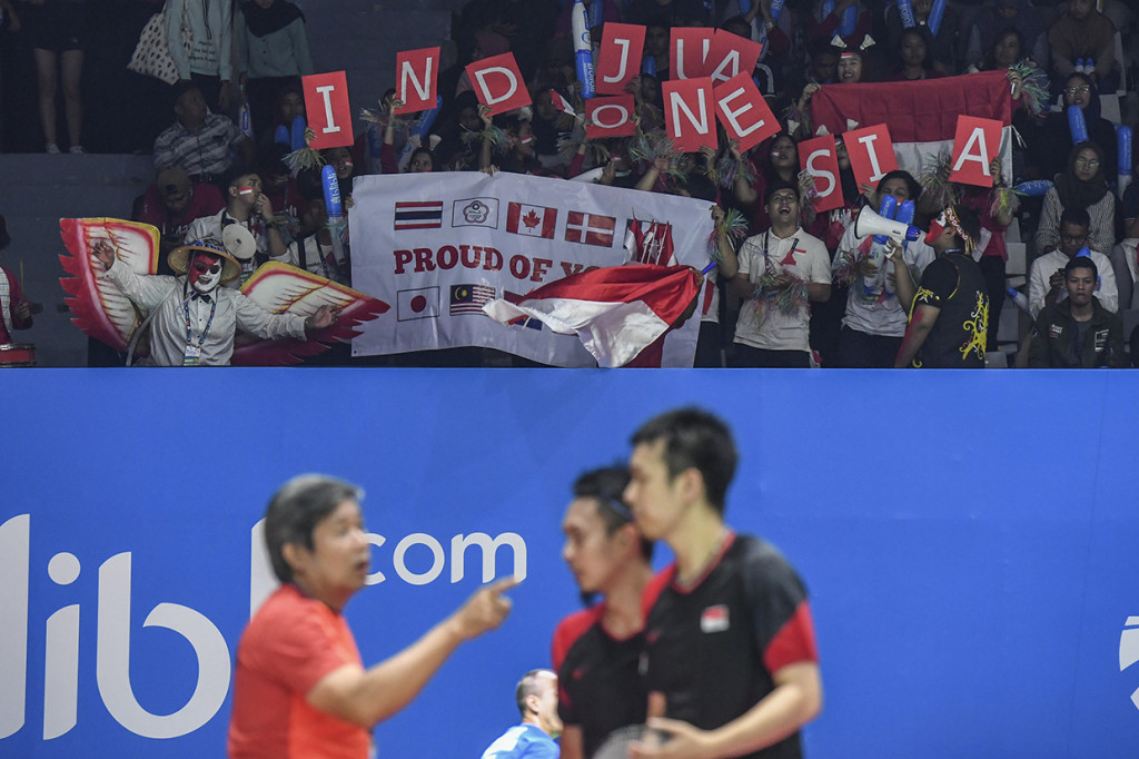 Suporter meneriakan yel-yel saat pertandingan ganda putra Indonesia Mohammad Ahsan dan Hendra Setiawan melawan ganda putra Inggris Marcus Ellis dan Chris Langridge pada babak pertama Blibli Indonesia Open 2019 di Istora Senayan, Jakarta.