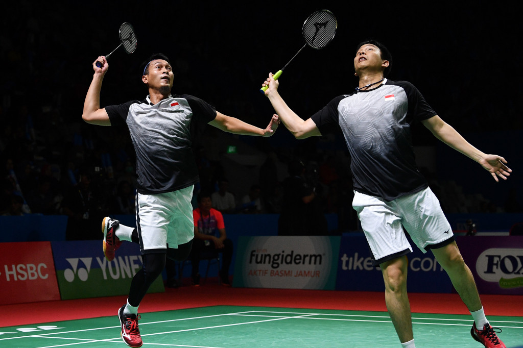 Ganda putra Indonesia Mohammad Ahsan (kiri) dan Hendra Setiawan melompat untuk mengejar kok dari ganda putra Jerman Mark Lamsfuss dan Marvin Seidel dalam babak kedua Blibli Indonesia Open 2019 di Istora Gelora Bung Karno, Jakarta.