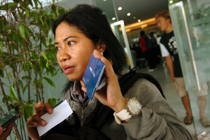 Marina, salah satu nasabah Bank Mandiri, menunjukkan kartu tabungan dan ATM saat aksi protes di Bank Mandiri Cabang Tegal, Jawa Tengah, Sabtu, 20 Juli 2019.