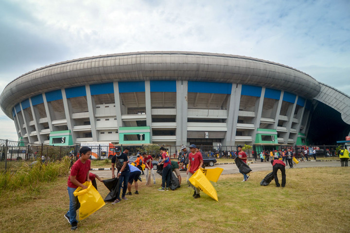 Relawan membersihkan rumput liar dan sampah yang sebelumnya berserakan di halaman Stadion Gelora Bandung Lautan Api (GBLA), Gedebage, Bandung, Jawa Barat, Sabtu, 20 Juli 2019. 
