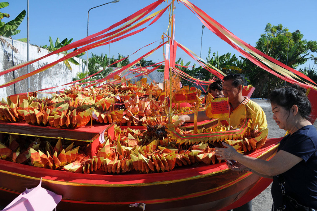 Umat Buddha menyiapkan replika kapal sebelum dibakar ketika memperingati Dewi Kwan Im mencapai kesempurnaan di Vihara Avalokitesvara, Pamekasan.