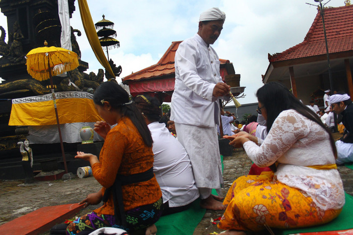 Pemuka agama Hindu memercikkan air suci pada umat saat perayaan Hari Raya Galungan di Pura Luhur Giri Arjuno, Batu, Jawa Timur, Rabu, 24 Juli 2019. Antara Foto/Ari Bowo Sucipto