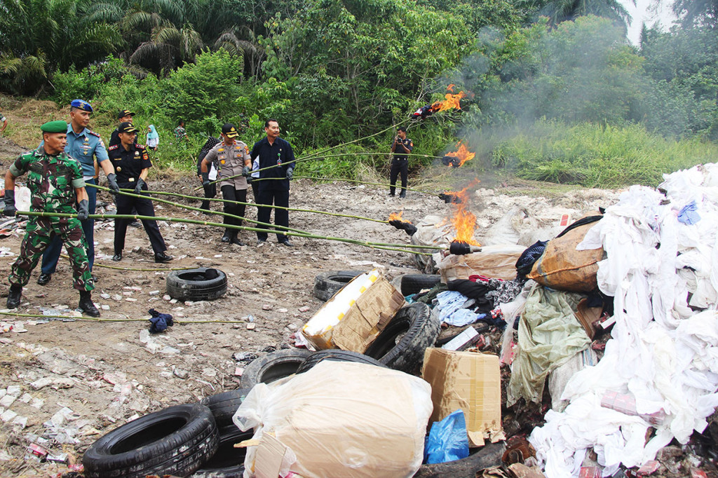 Petugas otoritas kepabeanan dan sejumlah aparat penegak hukum membakar barang bukti hasil selundupan di Detasemen Arhanud Rudal 004 Dumai, di Dumai, Riau, Rabu, 24 Juli 2019. 