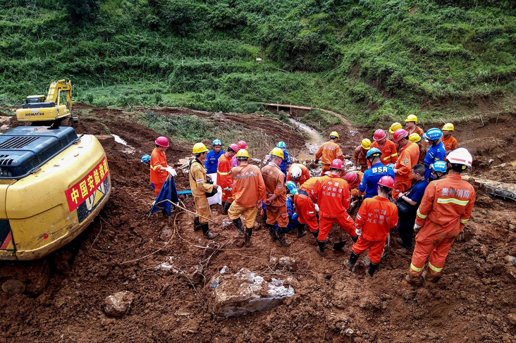 Puluhan petugas penyelamat berusaha untuk mencari korban hilang, dengan menyisir timbunan tanah longsor di sebuah desa di daerah Shuicheng, Provinsi Guizhou, Kamis, 25 Juli 2019. 