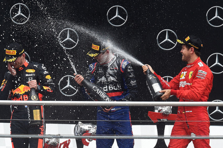 Verstappen naik podium bersama Sebastian Vettel sebagai runner up dan Daniil Kvyat di posisi ketiga. Afp Photo/Christof Stache