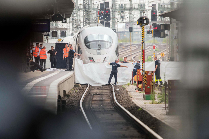 Polisi dan petugas kereta api menutupi lokasi seorang bocah dan ibunya yang tertabrak kereta api setelah didorong oleh seseorang yang tidak dikenal dari peron di stasiun kereta api Frankfurt am Main, Jerman, Senin, 29 Juli 2019 waktu setempat.