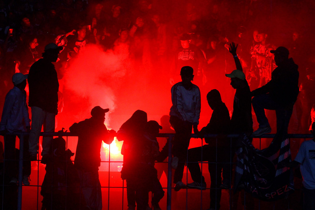 Suporter Arema FC (Aremania) berusaha menghentikan rekannya yang menyalakan cerawat usai pertandingan Liga I antara Arema melawan Persib Bandung di stadion Kanjuruhan, Malang, Jawa Timur.