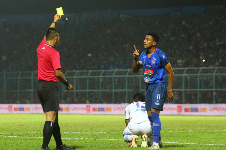 Wasit Aprisman Aranda (kiri) memberi kartu kuning pada pesepakbola Arema FC Rivaldi Bawuo (kanan) yang melakukan pelanggaran keras pada pesepakbola Persib Bandung Febri Hariadi (tengah) dalam pertandingan Liga I di stadion Kanjuruhan, Malang, Jawa Timur.
