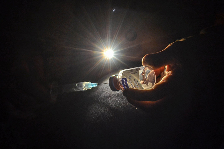 Petugas tengah berusaha menangkap macan tutul yang ditemukan warga saat sedang berburu musang tersebut dengan cara ditembak obat bius. 