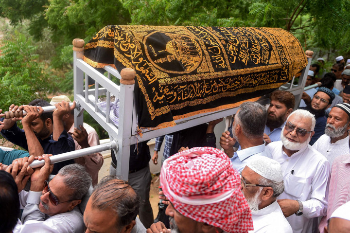 Warga menggotong peti berisi jenazah seorang bocah laki-laki yang tersengat listrik yang disebabkan oleh kabel listrik yang tidak dirawat dengan baik selama hujan deras melanda Karachi, Pakistan, Rabu, 31 Juli 2019.