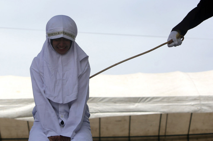 Terpidana pelanggar hukum syariat Islam menangis saat menjalani eksekusi hukuman cambuk di halaman Masjid Baitushalihin Ulee Kareng, Banda Aceh, Kamis, 1 Agustus 2019.