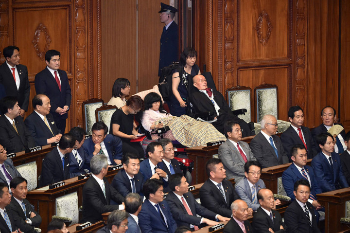 Yasuhiko Funago dan Eiko Kimura memenangkan kursi parlemen pada bulan lalu dalam pemilihan majelis tinggi, harus menggunakan kursi roda sandaran khusus yang telah dimodifikasi saat menghadiri sesi sidang pertama parleman.