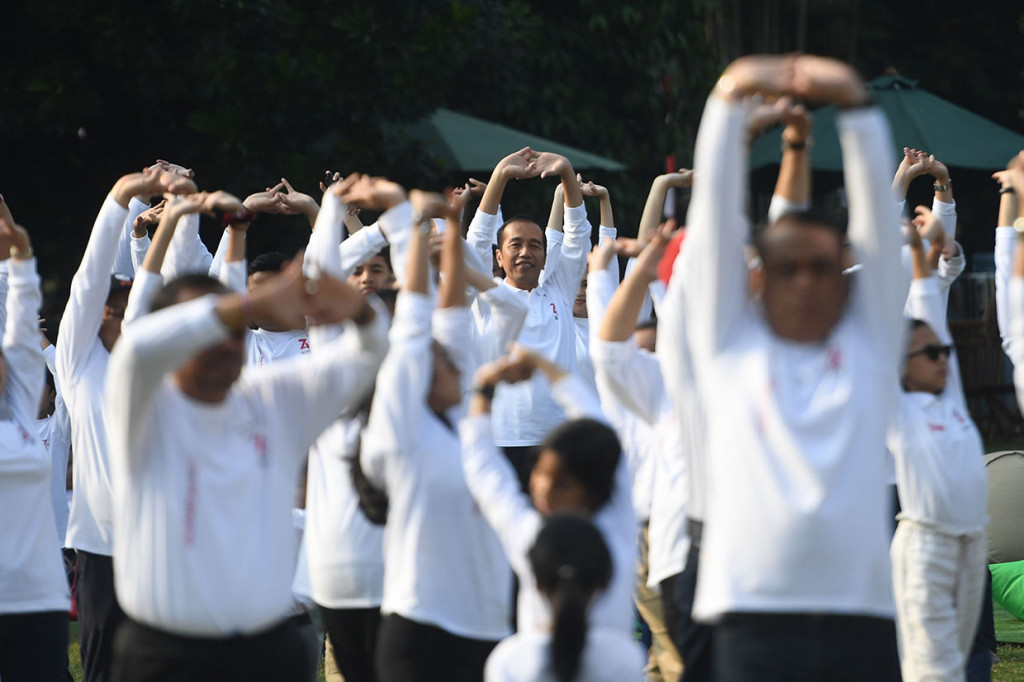 Presiden Joko Widodo (tengah) melakukan senam bersama jajaran menteri dan keluarganya saat 