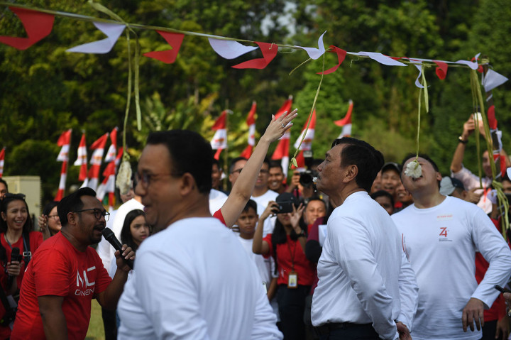 Menko Kemaritiman Luhut Binsar Pandjaitan (tengah), Mantan Mendikbud yang sekarang menjabat sebagai Gubernur DKI Jakarta Anies Baswedan (kiri) dan Kepala Bekraf Triawan Munaf (kanan) mengikuti lomba makan kerupuk saat 