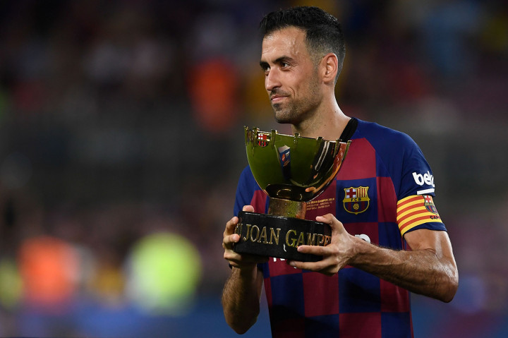 Gelandang Spanyol Barcelona Sergio Busquets memegang trofi setelah pertandingan persahabatan Joan Gamper Trophy yang ke-54 antara Barcelona dan Arsenal di stadion Camp Nou.