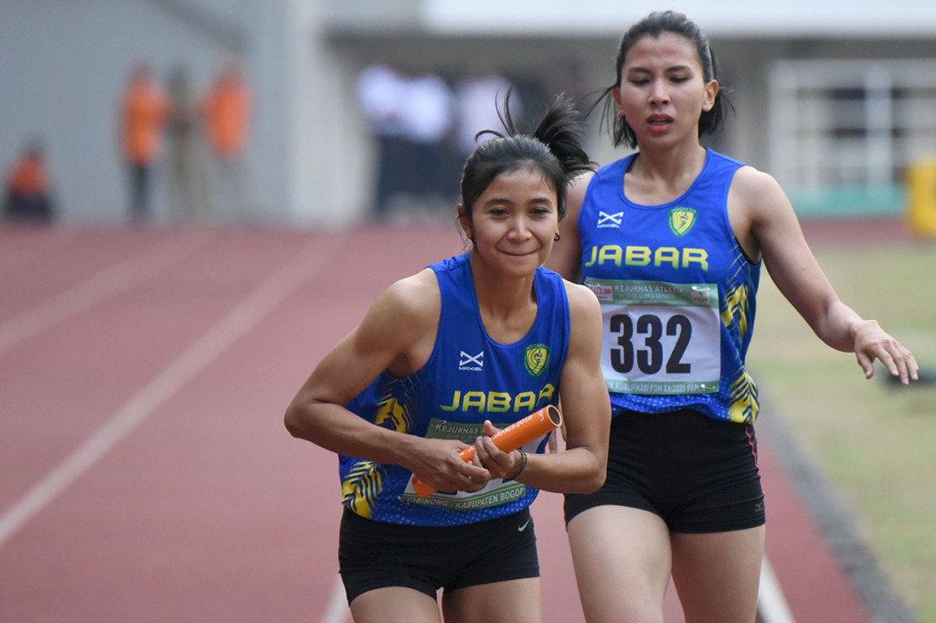 Pelari tim estafet putri Jawa Barat Emma Anita (kiri) menerima tongkat estafet dari pelari Mira Maryanti (kanan) pada final Lari Estafet nomor 4x400 meter Senior Putri pada Kejuaraan Nasional Atletik di Stadion Pakansari, Cibinong, Bogor, Jawa Barat.