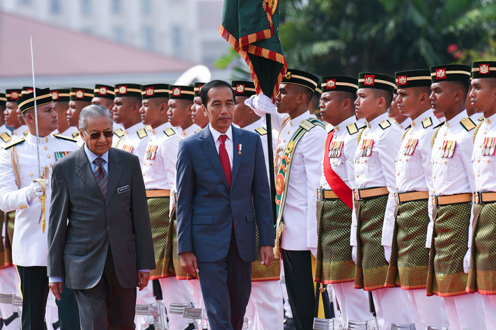 Jokowi dan Mahathir Mohamad melakukan pemeriksaan barisan saat Upacara Penyambutan Resmi di Putrajaya.
