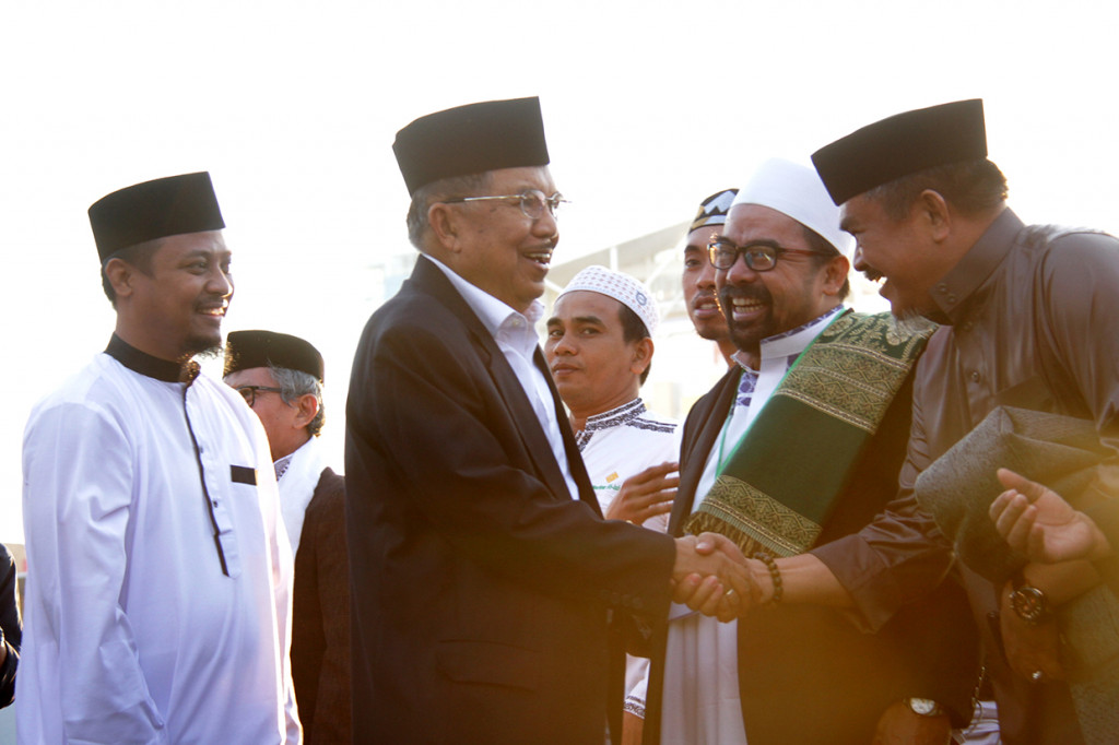 Wakil Presiden Jusuf Kalla (kedua kiri) bersama Wakil Gubernur Sulawesi Selatan Andi Sudirman Sulaiman (kiri) menyalami jemaah shalat Idul Adha 1440 H saat tiba di Lapangan Karebosi, Makassar, Sulawesi Selatan.