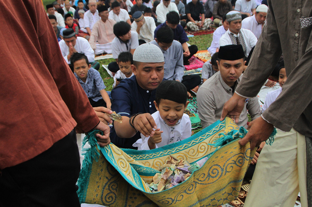 Dua remaja berkeliling sambil mengambil uang sedekah jamaah salat Idul Adha 1440 H di Lapangan Sepak Bola Sorumba, Kecamatan Ranomeeto, Konawe Selatan, Sulawesi Tenggara. Antara Foto/Jojon